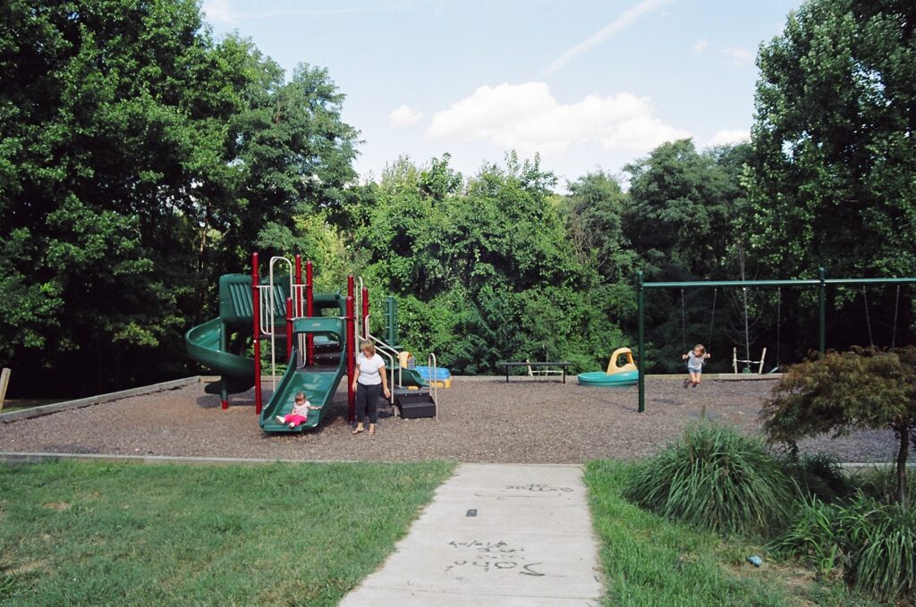 Playground with slides and swings and children playing.
