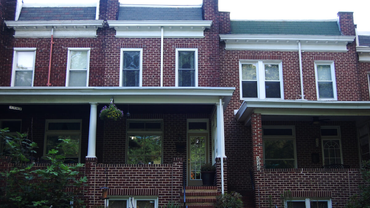 Brick rowhoomes with brick porches and green roofs.